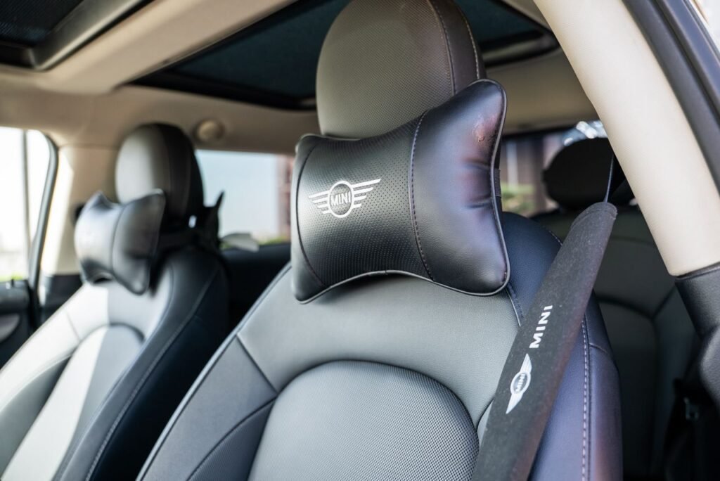 Interior of a modern car with plush leather seats and branded headrest, offering a luxurious driving experience.